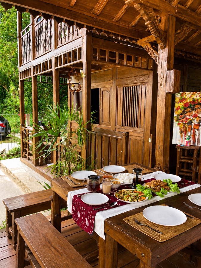 Wooden dining table set beside the traditional villa architecture