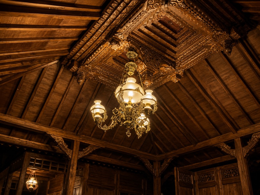 Carved Joglo ceiling and chandelier inside the traditional wooden pavilion at Villa Hola Agung