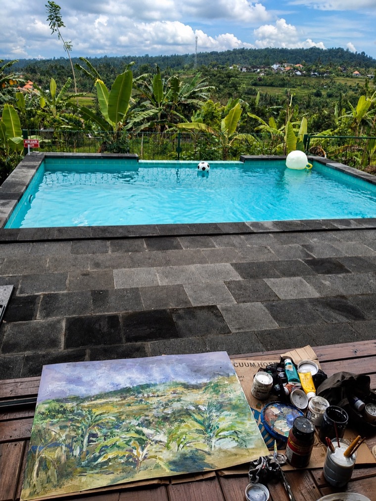 Painting materials and a landscape study beside the pool at Villa Hola Agung