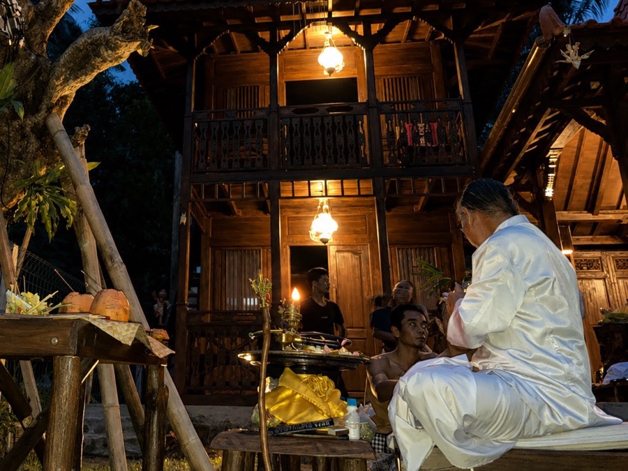 Purification ceremony moment near the traditional wooden buildings at Villa Hola Agung